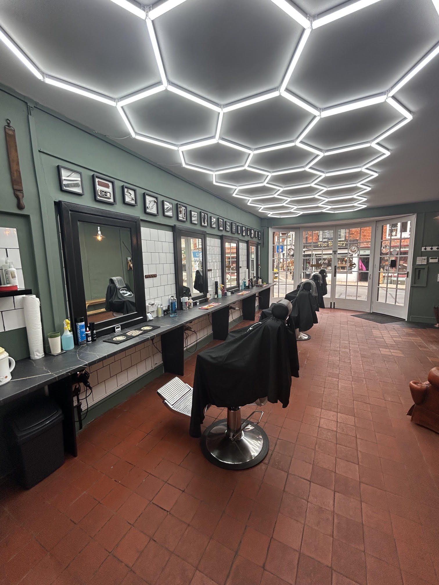 Inside Smooth Operators: a row of barber chairs and mirrors under the hexagon ceiling lights