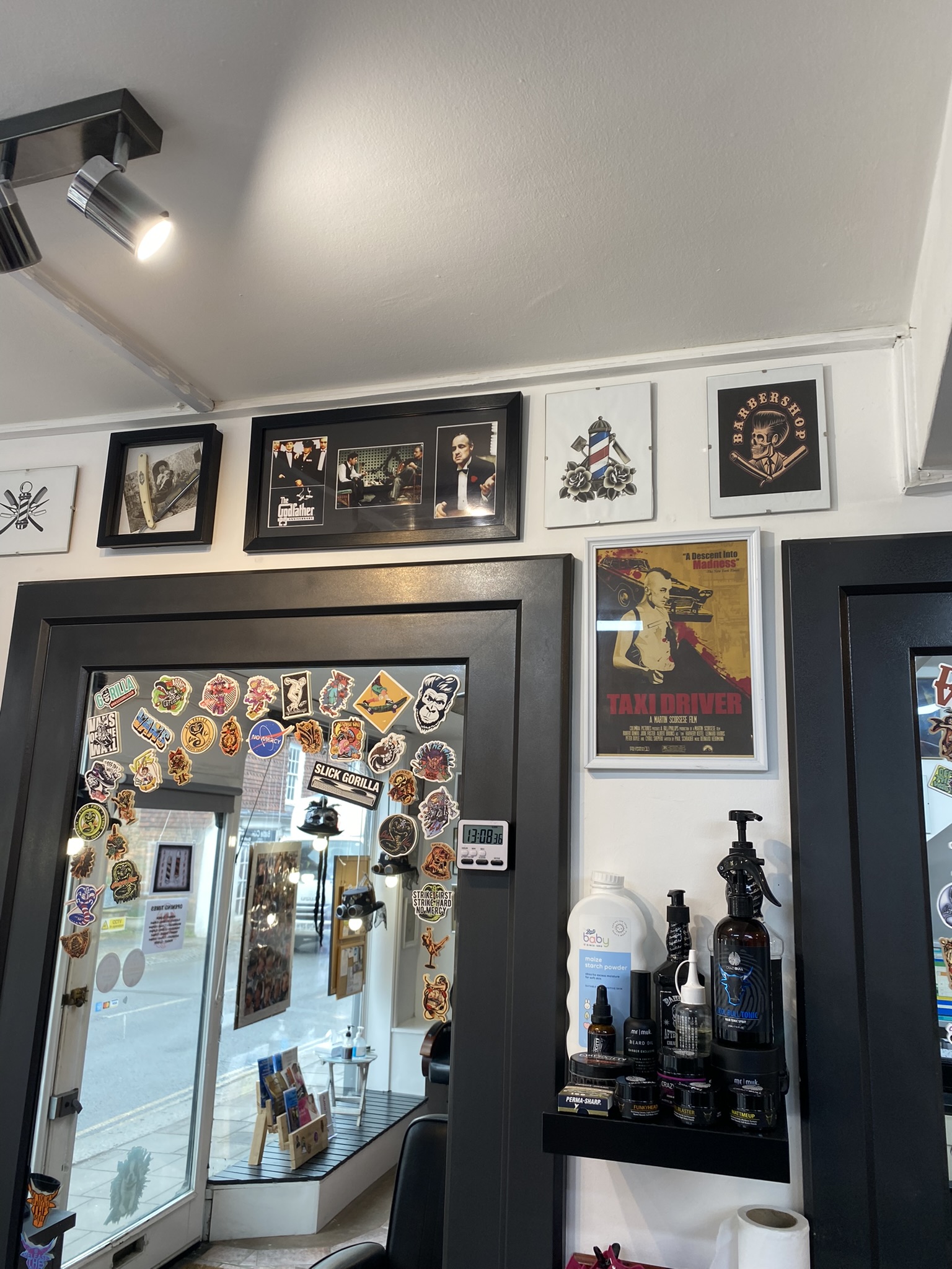 Framed pictures and a sticker-covered mirror on the shop wall